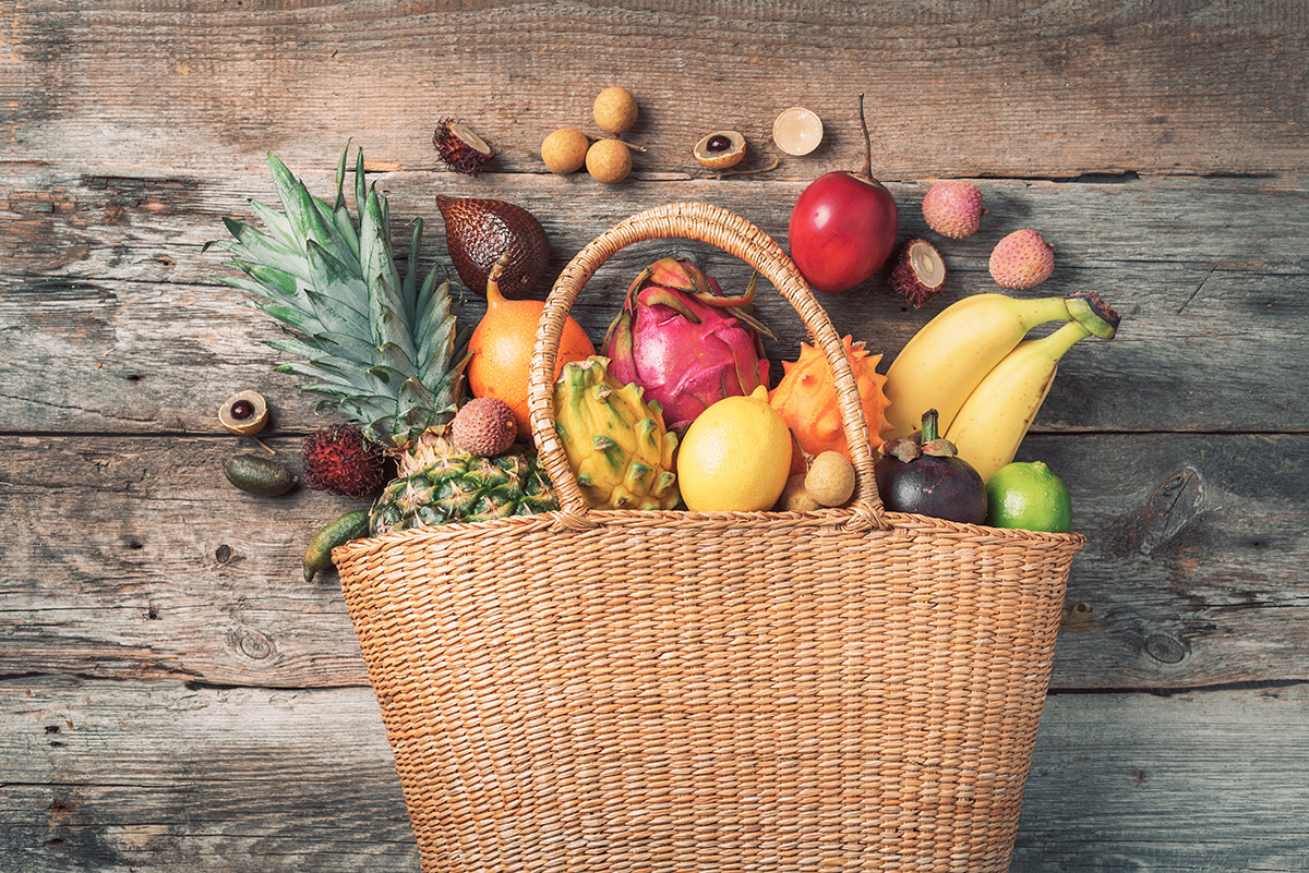 tropical-fruits-in-a-basket-on-wooden-background